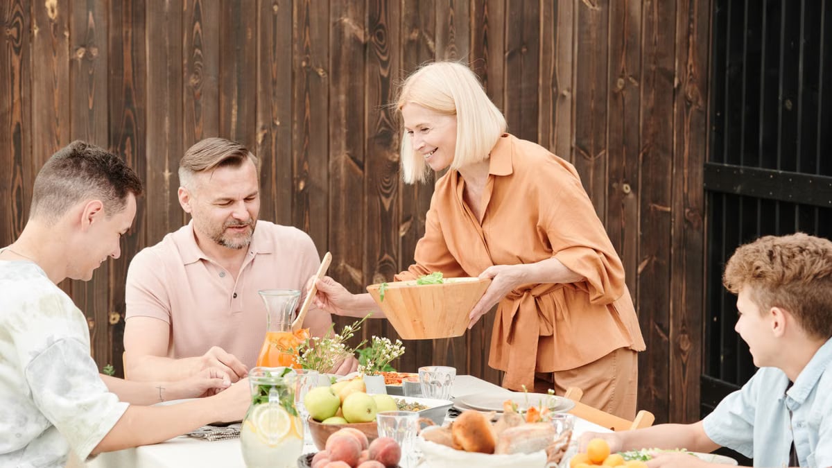 A joyful family gathering outdoors enjoying a meal together with laughter and connection.