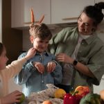 Mother and children have fun unpacking vegetables in the kitchen.